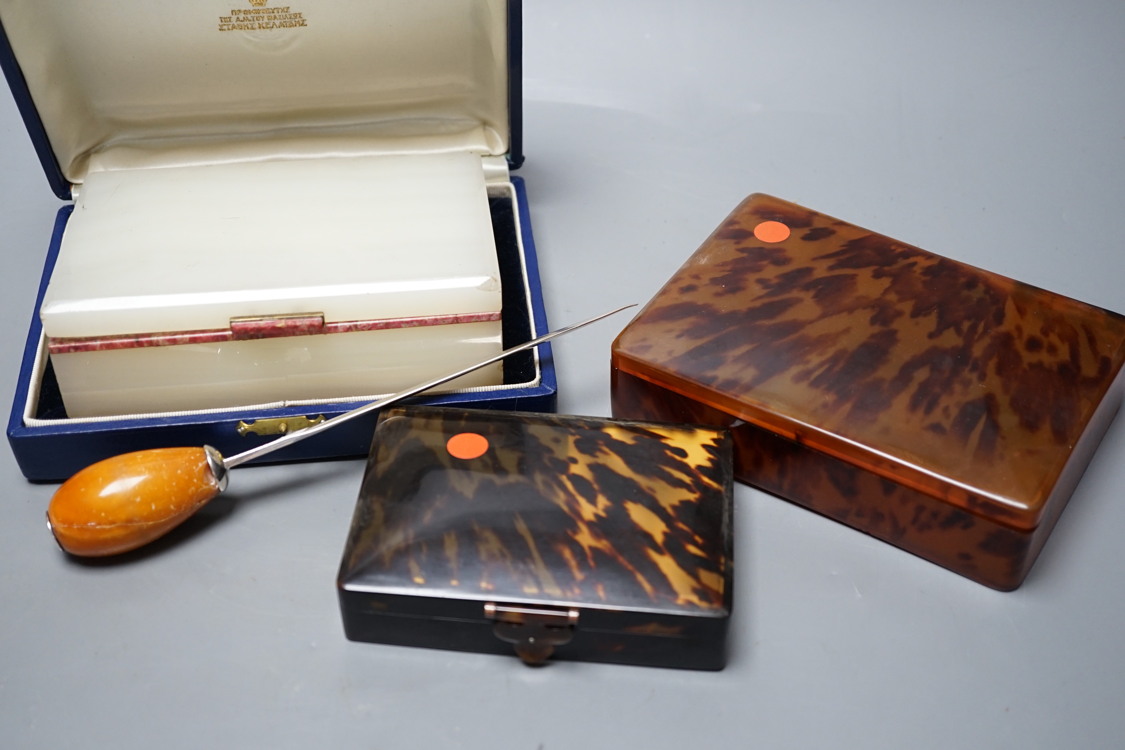 Two tortoiseshell boxes, an onyx cigarette box (does not fit case) and a Baltic amber handled silver paperknife